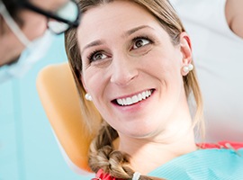 Woman in dental chair smiling at her cosmetic dentist