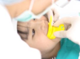 Child receiving fluoride treatment in dental office