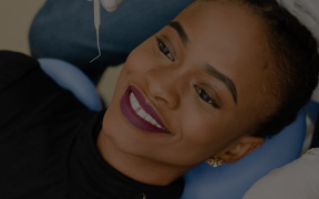 Smiling woman in dental chair before receiving dental exam