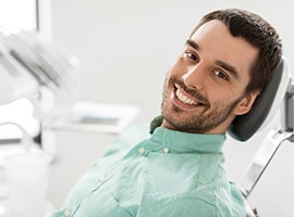 Male patient leaning back in chair and smiling