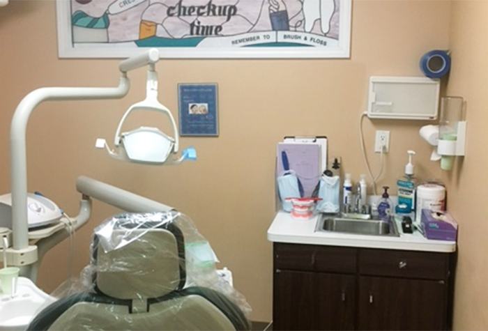 Dental exam room with model of teeth on sink in corner
