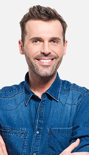 Man in denim shirt smiling with arms crossed