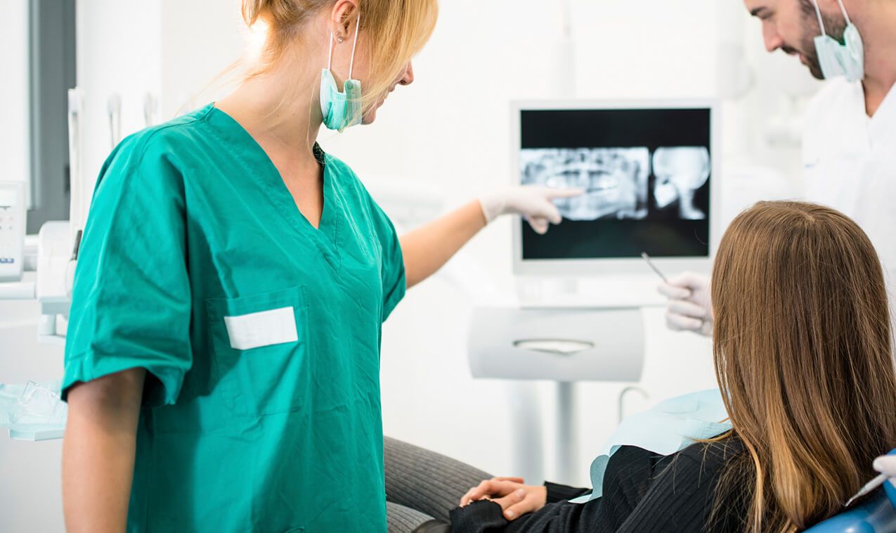 Dentist and patient looking at digital x rays of teeth