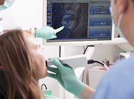 Dentist and patient looking at intraoral photos of patient's mouth